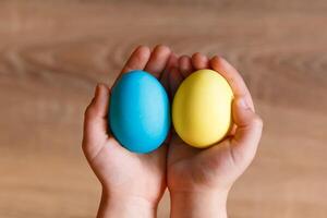 Paint eggs for Easter, bright Easter holiday, children paint eggs, colored eggs in a basket, colored eggs on a stand, Holiday background photo