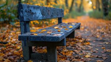 AI generated Close up of a weathered wooden bench in autumn with fallen leaves on the floor photo