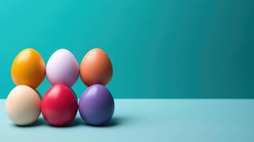 AI generated Colorful Easter eggs stacked on a blue surface with turquoise wall background and copy space photo