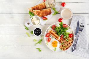 English breakfast. Keto breakfast. Fried egg, beans, chicken sausage and coffee cup. Top view, flat lay photo