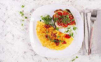 Omelette with cheese and toast with tomatoes on white plate.  Frittata - italian omelet. Top view, flat lay photo