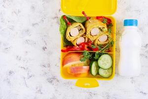 School lunch box with sausage roll in omelette with lavash. Lunchbox. Keto lunch. Top view, flat lay photo