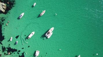 Aerial panoramic view of seascape with crystal clear azure sea and rocky shores. Yachts in a beautiful lagoon on backdrop of rocks. The concept of an ideal destination for summer travel and vacation. video