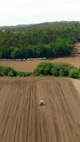 verticale video di trattore nel agricoltura campo aereo Visualizza