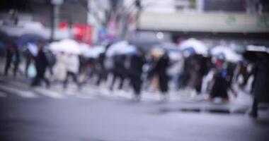 caminando personas a el shibuya cruce lluvioso día desenfocado video