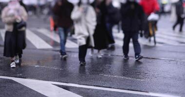 un lento movimiento de caminando personas a el shibuya cruce día lluvioso video