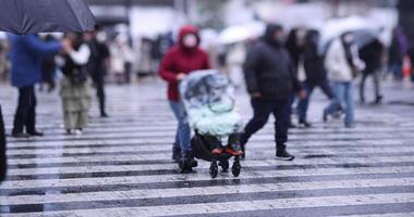 un lento movimiento de caminando personas a el shibuya cruce día lluvioso video