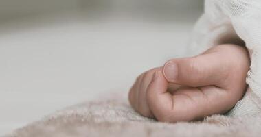 A 2x slow motion of sleeping asian baby left hand on the carpet handheld video