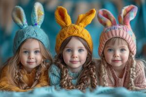 ai generado Tres linda pequeño muchachas son acostado en el cama en calentar de punto sombreros con orejas de liebre en azul antecedentes. foto