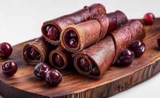 AI generated Tasty chocolate rolls with cherries on wooden board. Handmade fruit pastilles photo