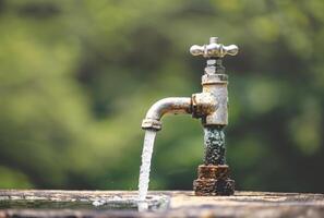 ai generado agua es fluido desde el antiguo grifo foto