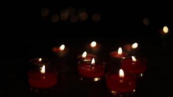 Burning candles on dark surface. Many burning candles with shallow depth of field. video