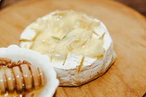 White baguette with olive oil and baked Camembert cheese on the table. photo