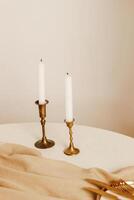 dorado candelabros con blanco velas en un beige interior. foto