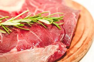 Fresh piece of meat large beef steak on the bone ossobuco with rosemary sprig. photo