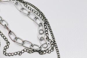 Different silver metal chains on a light background. photo