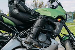 A girl sits on a motorcycle in protective moto overalls, safety equipment photo