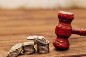 Judge's gavel on the table with Ukrainian hryvnias in coins. photo