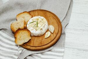 White baguette cut into pieces with olive oil and Camembert cheese on the table. photo