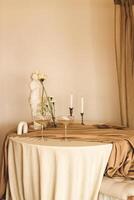 Stylish romantic table setting in the interior with glasses and candles. photo