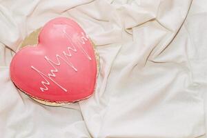 Heart shaped pink mousse cake on the table. photo