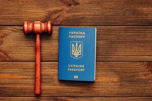 Ukrainian passport with a judge's gavel on a wooden table photo