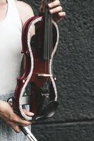 A fragment of an electric violin, a violin in the hands of a musician's girl photo