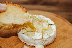 White baguette with olive oil and baked Camembert cheese on the table. photo