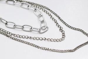 Different silver metal chains on a light background. photo