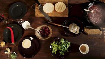 Haut vue de Hamburger Ingrédients sur une en bois table Contexte. Stock images. Camembert fromage, rouge le Chili poivre, persil, céleri, et sauces. video