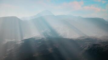 sun shining through clouds over mountains video