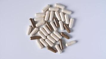 Close up of rotation soft white and gray pills or capsules on white background video