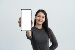 A woman is holding a cell phone with a white background. She is smiling and she is happy. Isolated on white background. photo