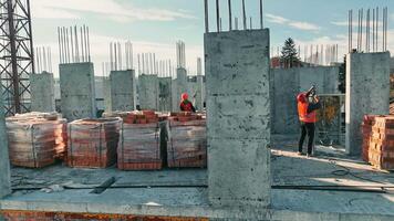 construcción obras. constructores son edificio otro piso de un de varios pisos ladrillo edificio. video