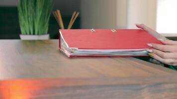 A female accountant takes a folder with documents from the table close-up video