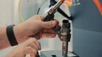 das Meister installiert das Treibstoff Injektor auf das Diagnose Stand. Treibstoff Injektion Ausrüstung Reparatur Stand video