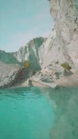 rotsachtig waterkant met berg achtergrond video