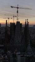 verticaal video van sagrada familia kathedraal, in Barcelona Bij zonsopkomst antenne visie