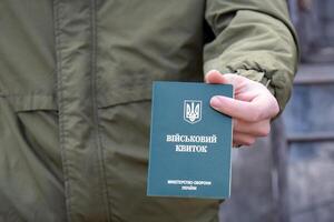 Ukrainian military ID in the hands of a young guy. photo