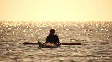mujer mar kayac. contento sonriente mujer en kayac en océano, remar con de madera remo. calma mar agua y horizonte en antecedentes. activo estilo de vida a mar. verano vacaciones. video