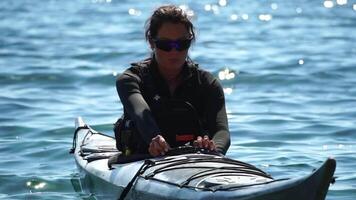 kvinna hav kajak. Lycklig leende kvinna i kajak på hav, paddling med trä- åra. lugna hav vatten och horisont i bakgrund. aktiva livsstil på hav. sommar semester. video