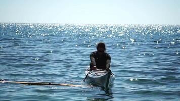 donna mare kayak. contento sorridente donna nel kayak su oceano, paddling con di legno remo. calma mare acqua e orizzonte nel sfondo. attivo stile di vita a mare. estate vacanza. video