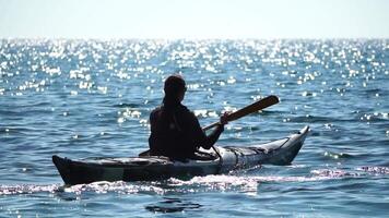 mulher mar caiaque. feliz sorridente mulher dentro caiaque em oceano, remar com de madeira remo. calma mar água e horizonte dentro fundo. ativo estilo de vida às mar. verão período de férias. video