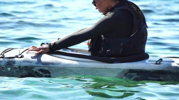 mujer mar kayac. contento sonriente mujer en kayac en océano, remar con de madera remo. calma mar agua y horizonte en antecedentes. activo estilo de vida a mar. verano vacaciones. video