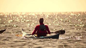 Woman sea kayak. Happy smiling woman in kayak on ocean, paddling with wooden oar. Calm sea water and horizon in background. Active lifestyle at sea. Summer vacation. video