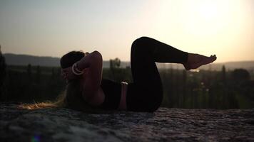 Young woman with long hair, fitness instructor in black Sportswear Leggings and Tops, stretching before pilates, early morning on sunrise, female fitness yoga routine concept video