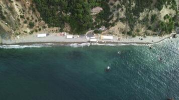 Antenne Aussicht auf Ruhe azurblau Meer und vulkanisch felsig Ufer. klein Wellen auf Wasser Oberfläche. Natur Sommer- Ozean Meer Strand Sicht. niemand. Urlaub, Ferien und Reise Konzept. Wetter und Klima Veränderung video