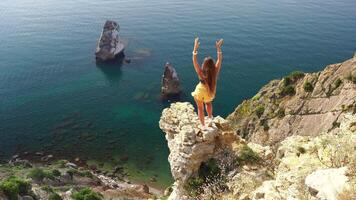 mujer verano viaje mar. contento turista disfrutar tomando imagen al aire libre para recuerdos. mujer viajero posando en el playa a mar rodeado por volcánico montañas, compartiendo viaje aventuras viaje video