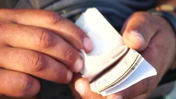 Close-up shot of a man's hands meticulously counting tickets. Slow motion video