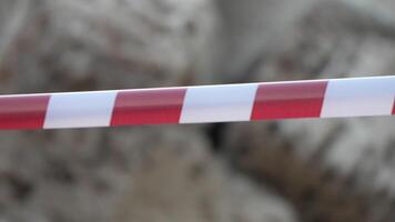 Red and white warning tape swinging in the wind. Protection sign. Don't cross the line. Red White caution tape pole fencing is protects for No entry. Backdrop without people, empty street. video